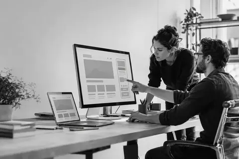 Webdesigner und Entwickler prüfen eine responsive Website auf mehreren Geräten